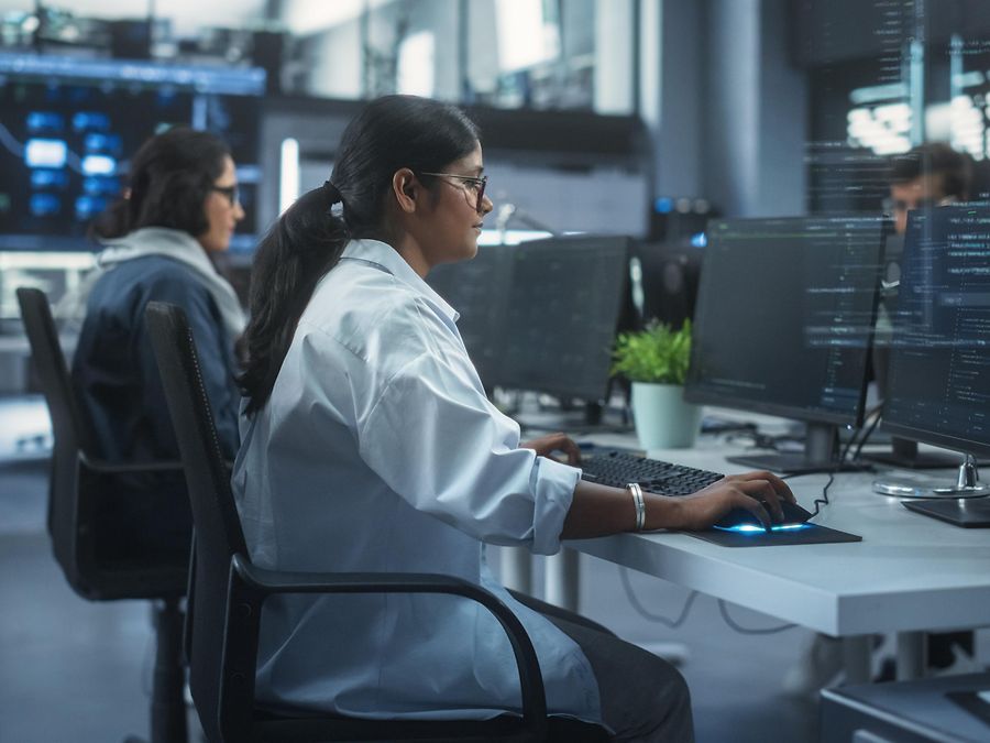 Frau vor dem Computer vor dunklem Hinetrgrund